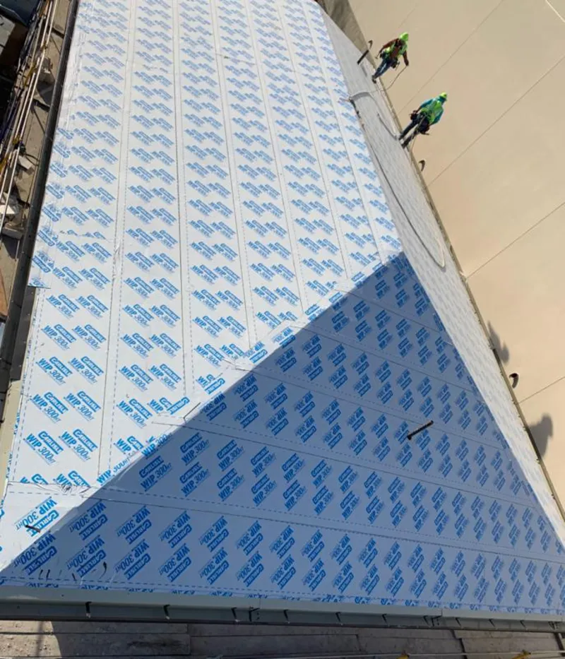 Professional roofers installing underlayment on a metal roof in Buckingham